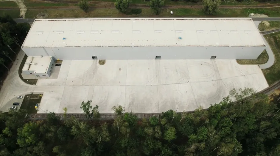 Betonowa nawierzchnia bezspoinowa wśród drzew, kadr z filmu dla Fibre System
